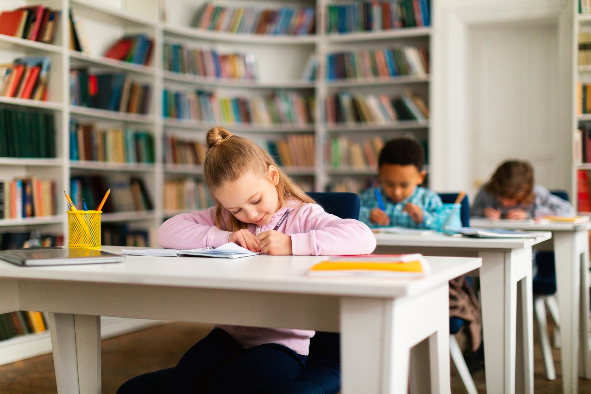 Diverse school children studying in primary school, doing homework or taking a grammar test, sitting