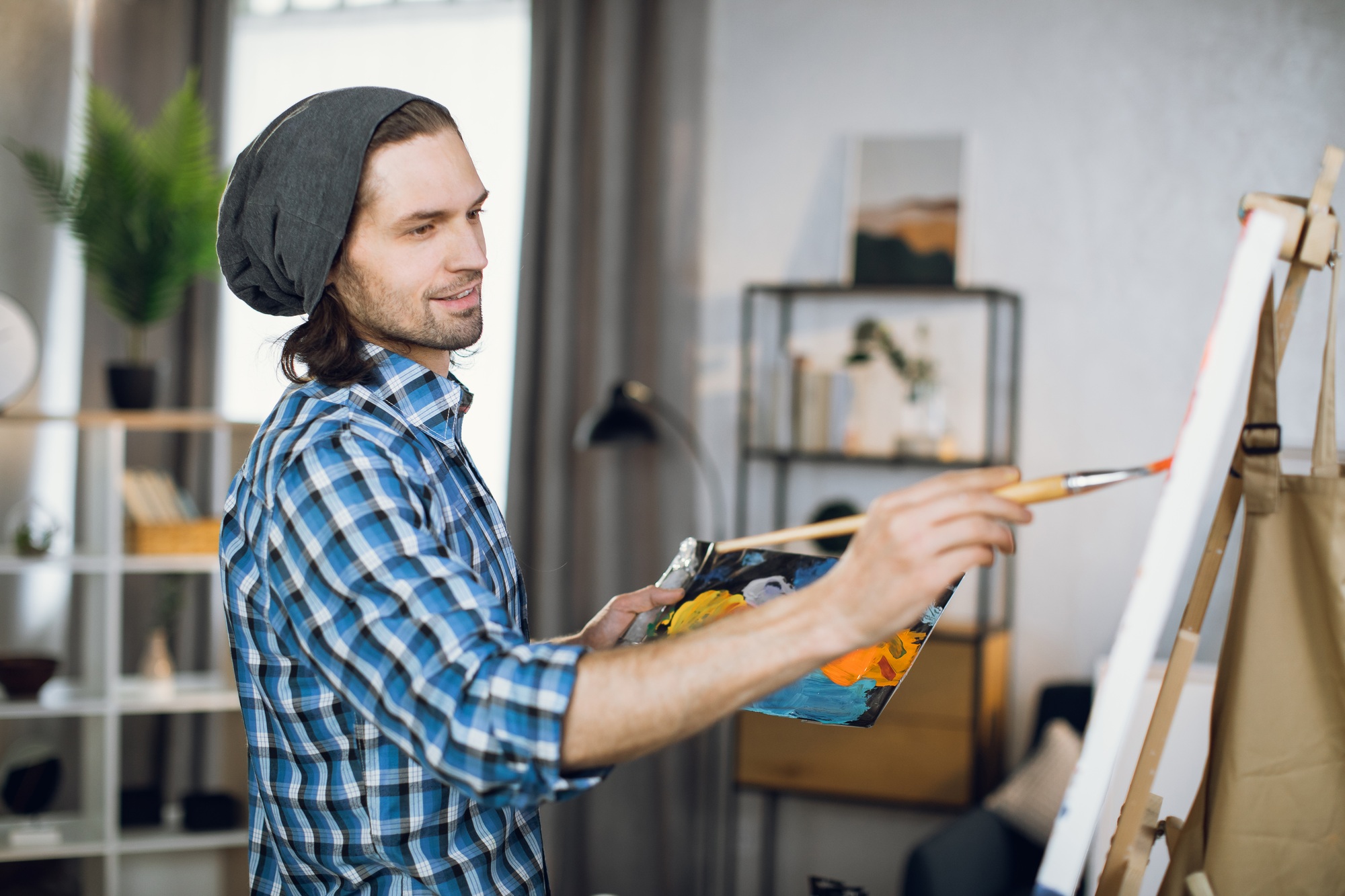 Man drawing with brush on canvas at art studio
