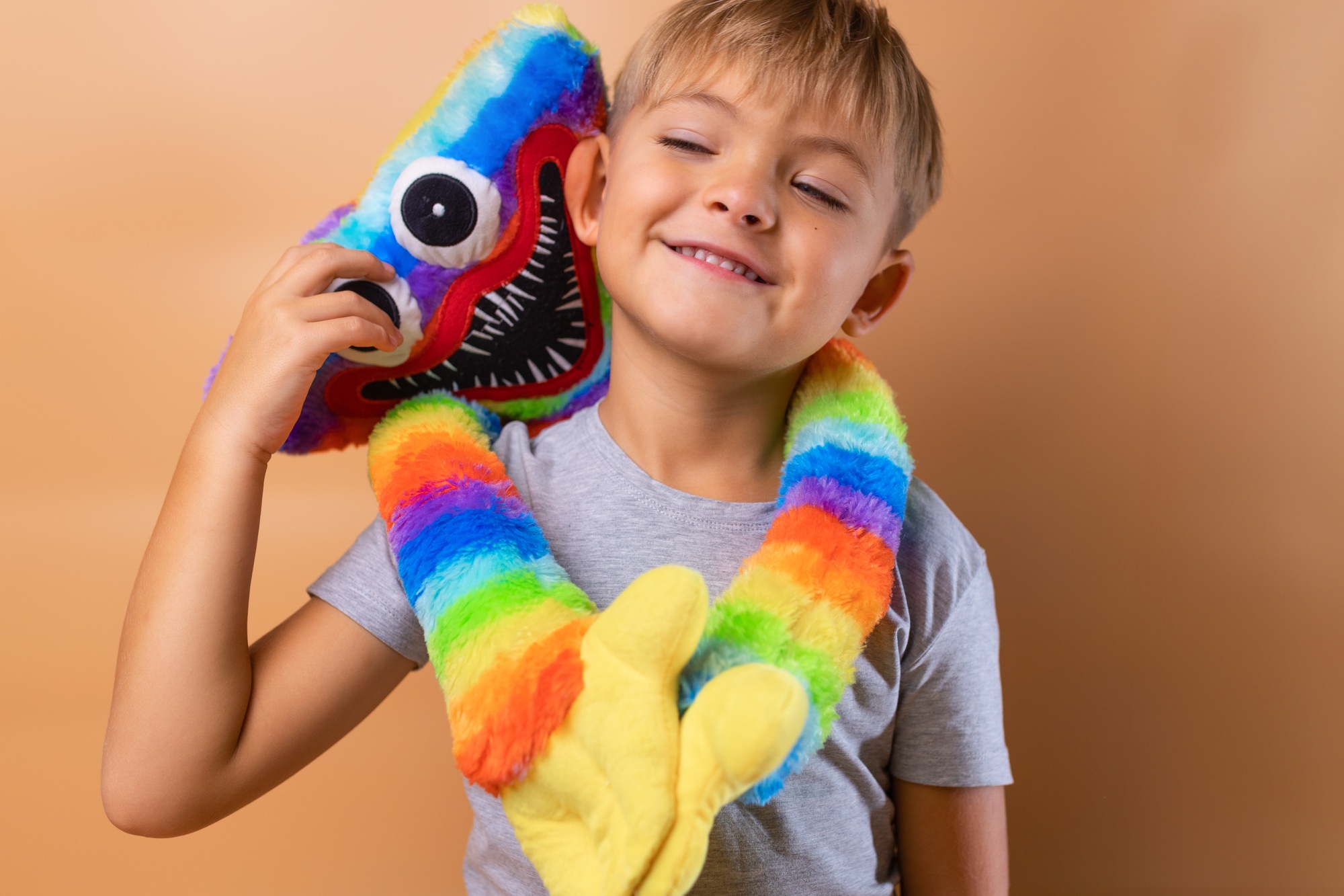 Positive little boy 6 years old with a bright colored toy. Concept: kindergarten, imaginary friend