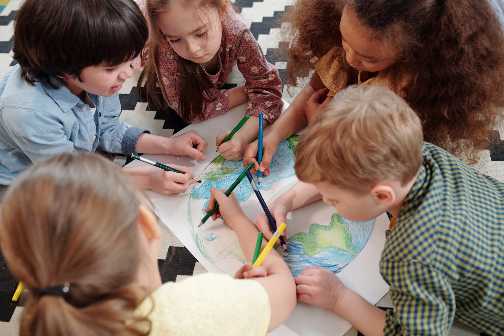 Several diligent kids drawing our planet